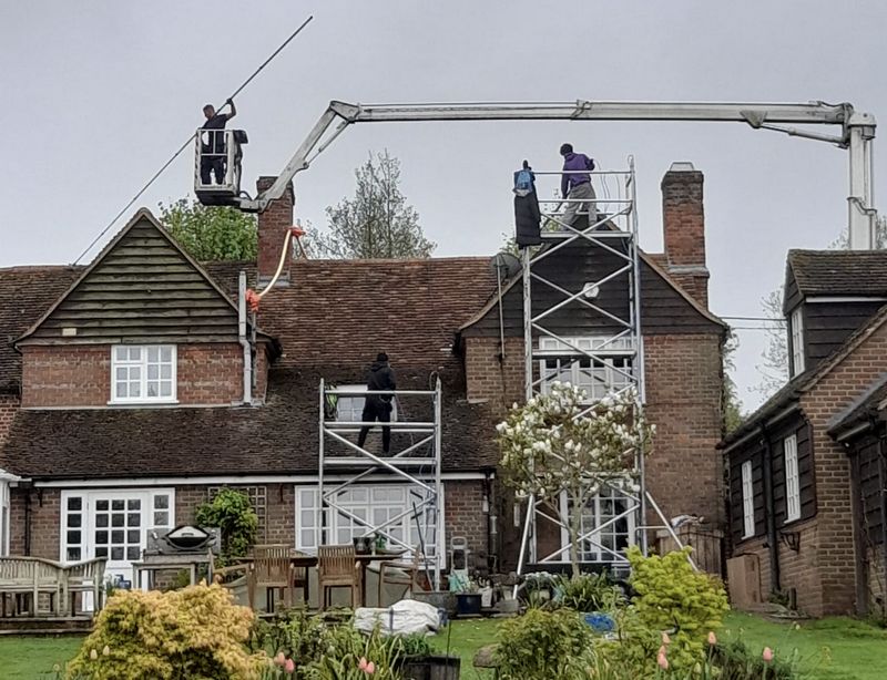 The Moss Cleaners using cherry picker and scaffolding to clean roof safely and professionally in Esher, Surrey